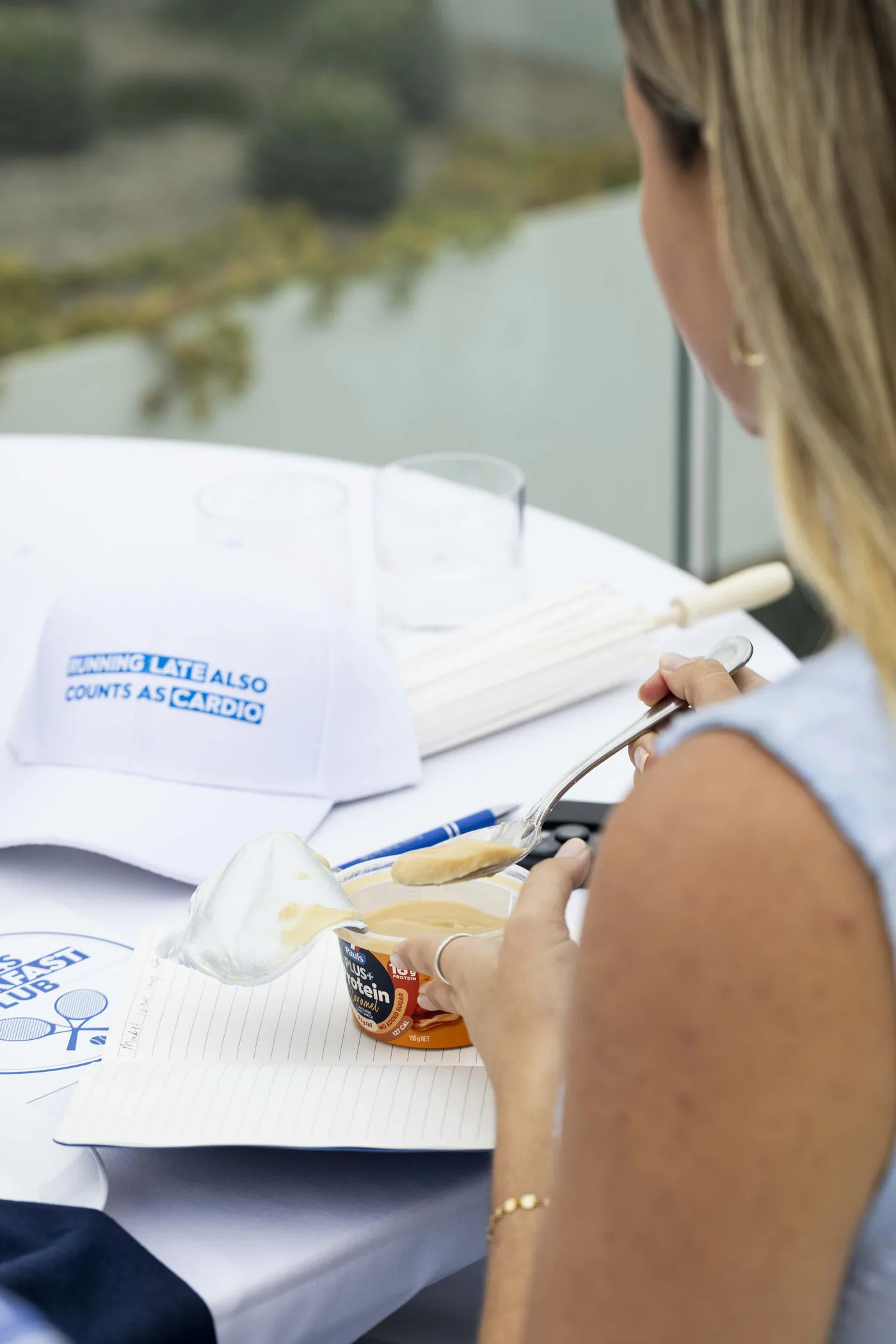 Detail of a Pauls PLUS+ Protein product with branded cap and notepad