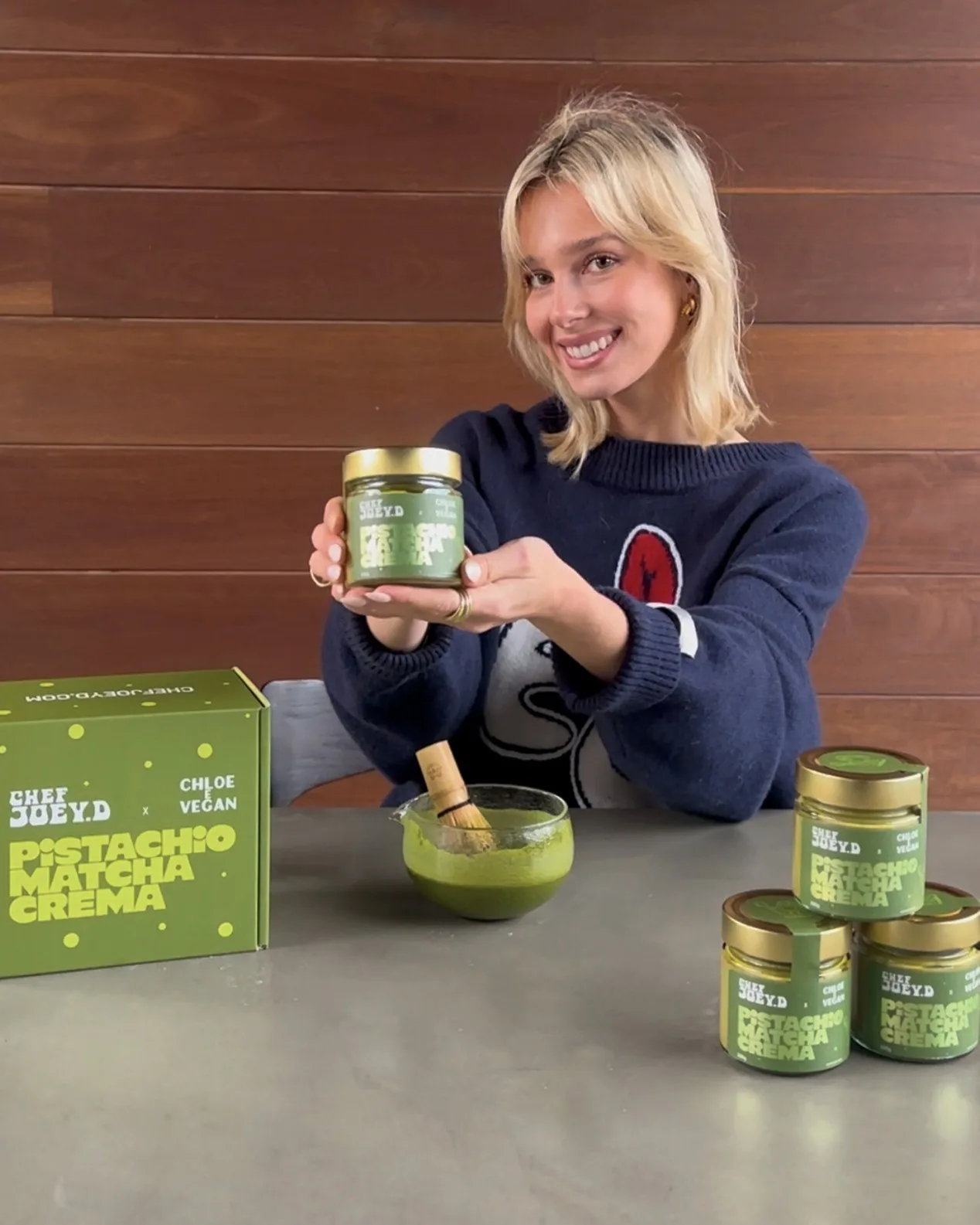 Chloe Wheatland holding a jar of Pistachio Matcha Crema