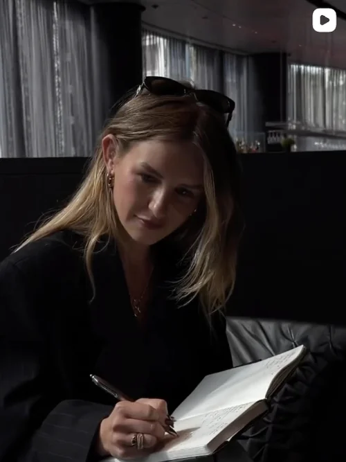 Made By Muse Instagram - Woman writing in a notebook at a lounge table
