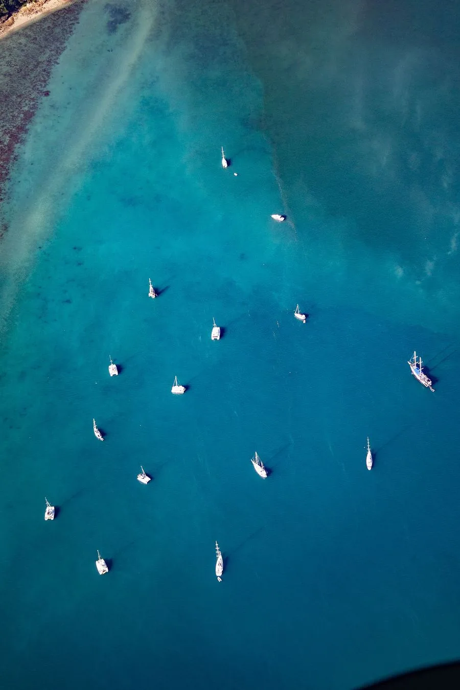 Yachts anchored off the Whitsundays coastline, seen from the air